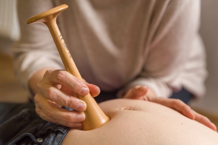 Bild von Händen, die ein Hörrohr auf schwangeren Bauch setzen