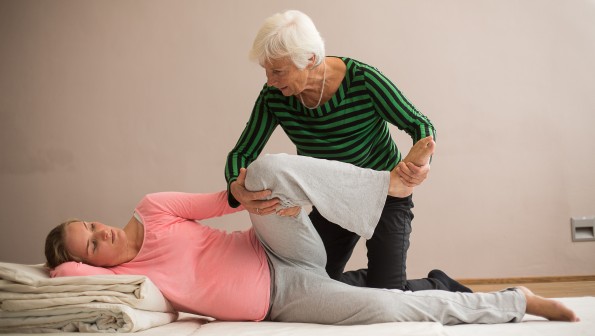 Schwangere und Hebamme üben eine Geburtsposition